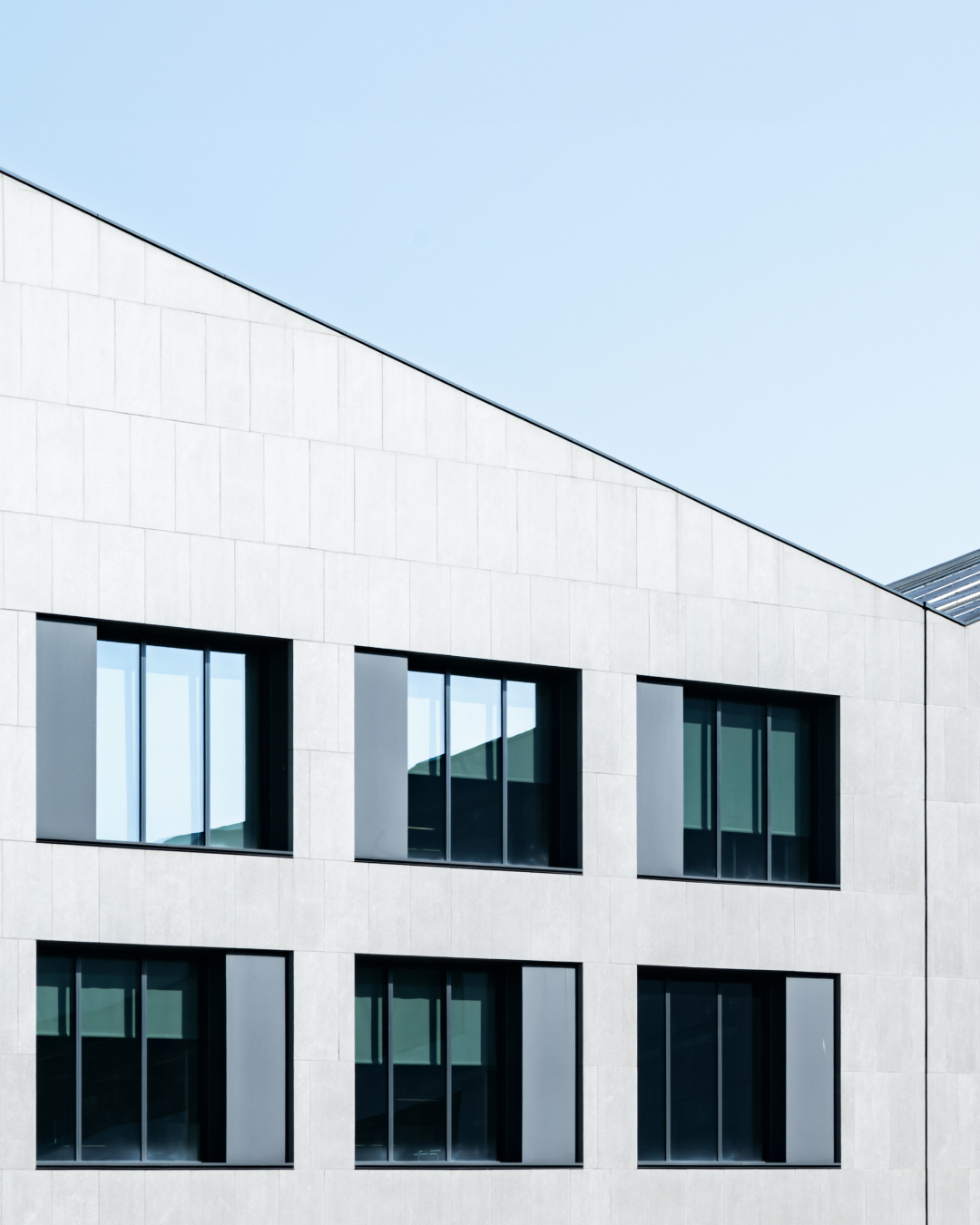 White building front elevation with 6 windows and blue sky