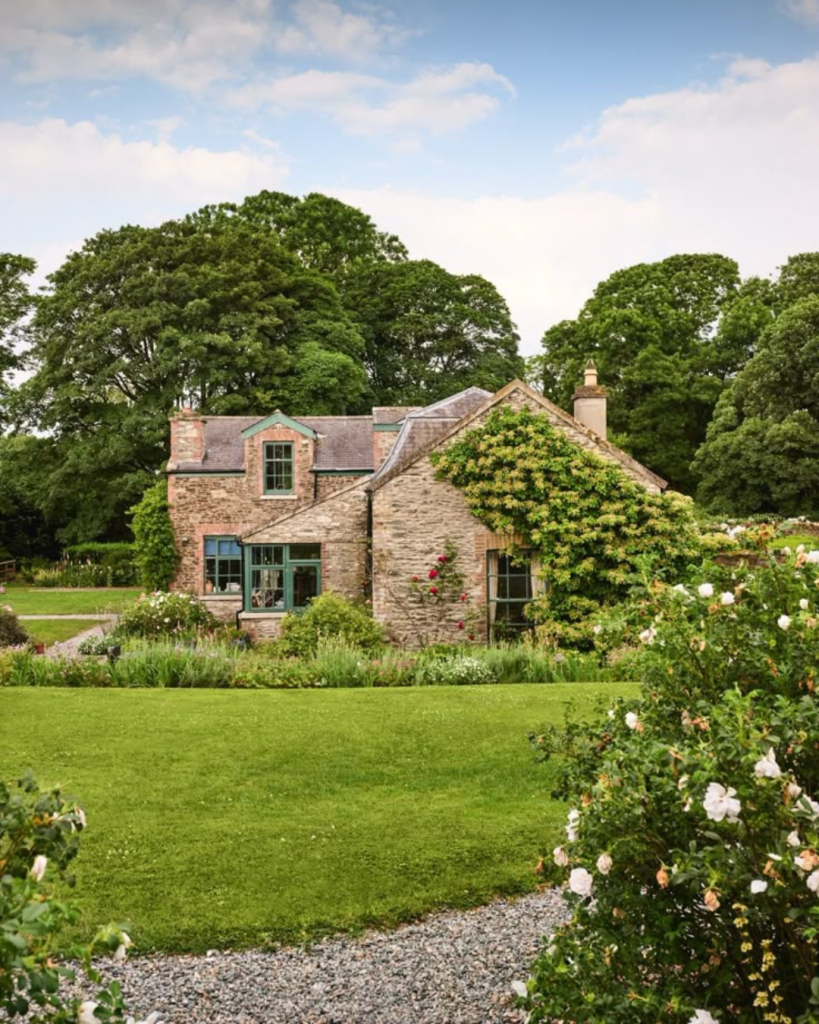 House set back in a garden with gravel driveway and trees surrounding it